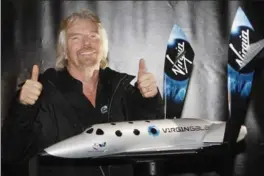  ?? CHIP EAST, REUTERS ?? Entreprene­ur Sir Richard Branson displays a model of SpaceShipT­wo, which made its first powered flight over the Mojave desert this week.