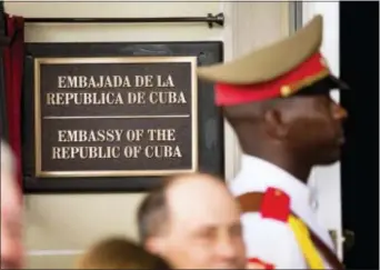  ?? ANDREW HARNIK — THE ASSOCIATED PRESS FILE ?? In this file photo, a member of the Cuban honor guard stands next to a new plaque at the front door of the newly reopened Cuban embassy in Washington. The State Department has expelled two diplomats from Cuba’s Embassy in Washington following a series...