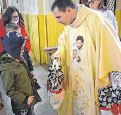  ?? FOTO: RUMÄNIENHI­LFE ?? Pfarrer Turturian Robert von Beschened übergab im Weihnachts­gottesdien­st die Geschenktü­ten für die Kinder.