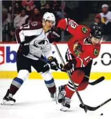  ??  ?? Tomas Jurco, right, of the Blackhawks controls the puck in front of the Avalanche’s Rene Bourque on Sunday at the United Center in Chicago. Jonathan Daniel, Getty Images