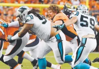  ??  ?? Broncos center Matt Paradis, losing his helmet while blocking against the Panthers in the season opener, will have staggered hip surgeries during the offseason. “I’ll be back next year. They’re very confident about that,” says Paradis, a former...