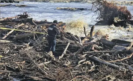  ?? Shmuel Thaler Santa Cruz Sentinel ?? A CAPITOLA police officer tapes off dangerous areas of driftwood along Capitola Beach as strong waves batter the state’s central coast.