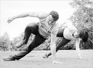  ??  ?? Nicole Tsong learns how to do the “lizard walk” with trainer Kyle Long. At left is the advanced “lizard walk. “