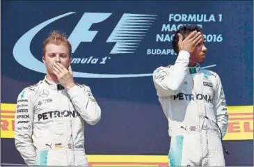  ??  ?? DISTANTES. Rosberg y Hamilton, ayer en el podio, antes de protagoniz­ar la rueda de prensa.