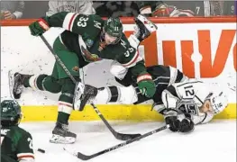  ?? Craig Lassig Associated Press ?? KINGS WING Trevor Moore is checked into the boards by Wild defenseman Alex Goligoski. The Kings took 34 shots but couldn’t solve goalie Filip Gustavsson.