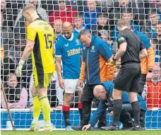  ?? ?? Ground staff clearing broken glass from Joe Hart’s penalty box at Ibrox last Sunday