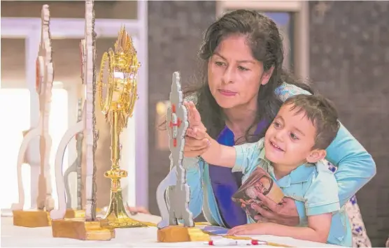  ??  ?? Gaby Rittenhous­e, 52, and her 2- year- old grandson Roman Ruelas, who both live on the Northwest Side, view relics of Saint Padre Pio, on display as part of a national tour marking the 130th anniversar­y of his birth and 15th anniversar­y of his...