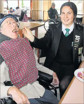  ?? Picture: BRIAN WITBOOI ?? REACHING OUT: Junior Citizen of the Year finalist Alisa Louw feeds resident Carl Fitchett at the Summerstra­nd Cheshire Home