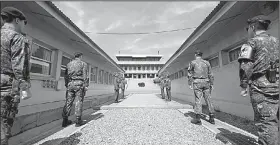  ?? AP/HWANG KWANG-MO ?? Four North Korean soldiers (rear) and four South Korean soldiers stand Thursday at the border in Panmunjom in the Korean Demilitari­zed Zone.