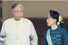  ?? AUNG SHINE OO/THE ASSOCIATED PRESS ?? Htin Kyaw, left, newly elected president of Myanmar, walks with pro-democracy leader Aung San Suu Kyi at the country’s parliament.