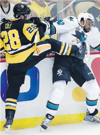  ?? GENE J. PUSKAR/THE ASSOCIATED PRESS ?? Pittsburgh’s Ian Cole, left, clashes with San Jose’s Joel Ward in the first period Monday. The Sharks are “looking forward to trying to redeem ourselves” in Game 2, Ward says.