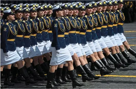  ?? ?? March past: Ranks of grinning Russian servicewom­en troop past Vladimir Putin yesterday