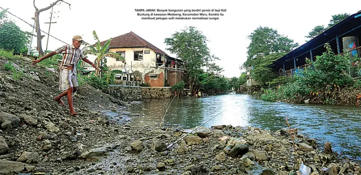  ?? BOY SLAMET/JAWA POS ?? TANPA JARAK: Banyak bangunan yang berdiri persis di tepi Kali Buntung di kawasan Medaeng, Kecamatan Waru. Kondisi itu membuat petugas sulit melakukan normalisas­i sungai.