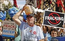  ?? ASSOCIATED PRESS 2012 ?? Ray Kemble, of Dimock, Pa., holds a jug of his well water while marching with demonstrat­ors against hydraulic fracturing in Philadelph­ia in September 2012. “It burns the back of your throat, makes you gag, makes you want to puke,” Kemble said this week...