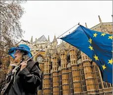  ?? KIRSTY WIGGLESWOR­TH/AP ?? An anti-Brexit campaigner waves an EU flag Tuesday in London. Parliament is starting to debate the exit deal.