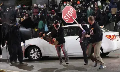  ??  ?? Protesters chase a street preacher, right, who was delivering a sermon during a protest againstpol­ice brutality in Tacoma, Washington, on 24 January. Photograph: Ted S Warren/AP