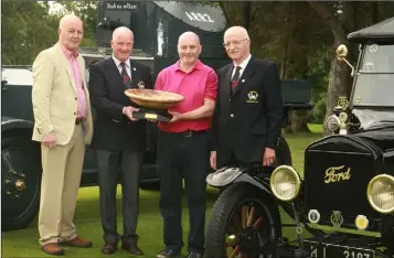  ??  ?? Artist Robert O’Connor, who sculptured the trophy, looks on as Courtown Captain John Fitzgerald presents his prize to the overall winner, Niall Slatter, with club President, George Kilbride, looking on. The quartet are pictured with the Sliabh na mBan...