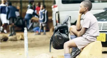  ?? REUTERS/Philimon Bulawayo/File Photo ?? A Zimbabwean schoolchil­d awaits transport from school during a teachers’ strike in Harare, Zimbabwe. -