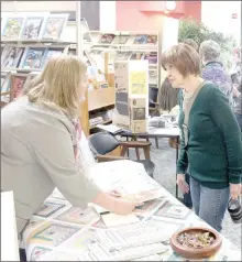  ?? Keith Bryant/The Weekly Vista ?? Local author Linda Pumphrey, left, talks with Debbie Saalfeld during the Local Author Showcase at the Bella Vista Library Saturday, March 18. Pumphrey said she has a history of working in the quilting industry and she wrote “Mountain Mist Historical...