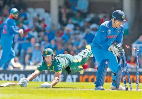  ?? AFP ?? AB de Villiers (L) dives to make his ground but MS Dhoni dislodges the stumps to signal the end of the South Africa skipper’s innings at the Oval on Sunday.