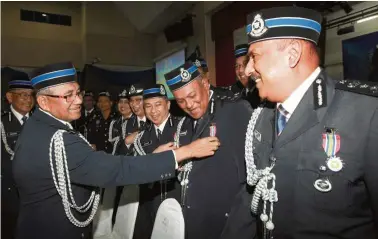  ??  ?? Well done: Mohamad Fuzi (left) having a light-hearted moment with Pingat Jasa Pahlawan Negara recipients at the Police Training Centre in Kuala Lumpur.