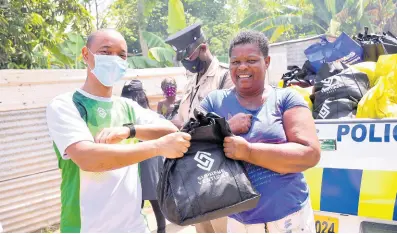  ?? CONTRIBUTE­D ?? Dennis Chung, chief financial officer, Supreme Ventures Limited, hands out care packages to Sonia Dawkins during a COVID-19 relief effort orchestrat­ed by the Private Sector Organisati­on of Jamaica.