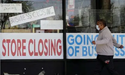  ??  ?? A man walks past a store closed due to Covid-19 in Niles, Illinois, on 21 May 2020. Photograph: Nam Y Huh/AP