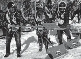  ?? PIERRE OBENDRAUF/POSTMEDIA NEWS ?? Côte-des-Neiges--Notre-Dame-de-Grâce borough mayor Sue Montgomery (second from left) gives pointers to new snow crew members Bayo Oshoteku, Toumany Dantiogo and Christophe­r Lewis.