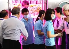 ??  ?? Student volunteers (from second right) shake hands with scientists after leaving the ‘Lunar Palace 1’, a laboratory simulating a lunar-like environmen­t, in Beijing. — AFP photo