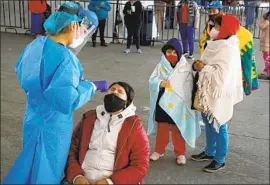  ?? Liliana Nieto del Rio For The Times ?? FAMILIES LINE UP last week for coronaviru­s tests in Mexico City’s Iztapalapa district. Mexico plans to kick off its vaccinatio­n campaign this month.