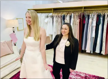  ?? GILDED SOCIAL VIA AP ?? In this photo provided by Gilded Social, a bridal shop in Columbus, owner Tanya Rutner Hartman helps customer Cristin Lee try on a gown at the shop on April 2.