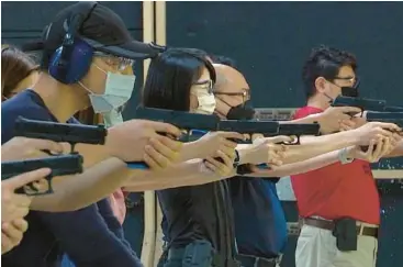  ?? WU TAIJING/AP ?? Taiwanese civilians practice shooting skills with air pistols June 21 at a private training facility in New Taipei City. China’s recent military exercises have underscore­d the self-ruled island’s need to bolster its civilian defense and reserve forces.