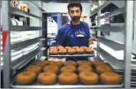  ?? AP ?? Matt Fein prepares doughnuts for a Phish concert at Federal Donuts in Philadelph­ia. The band works each night’s custom flavor into its setlists.