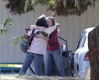  ?? RICH PEDRONCELL­I / AP ?? Two women embrace outside Rancho Tehama Elementary School, where a gunman opened fire Tuesday in Corning, California. Authoritie­s said that the gunman, choosing targets at random, opened fire in a rural Northern California town, killing four people at...