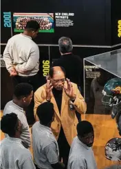  ??  ?? Pro Football Hall of Famer Elvin Bethea, 70, lends his expertise to a Gridiron Glory display item.
