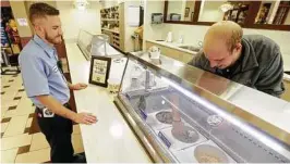  ?? Chronicle file photo / Melissa Phillip ?? Employee Robert Hilty, left, of Cypress is served ice cream by Matthew Danesi, right, of Brenham in the parlor at Blue Bell Creameries in Brenham.