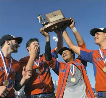  ??  ?? Jeannette’s Michael Pompei, left, Brendt Billeck, Eric Hall and Blaze Tran hoist the WPIAL Class 1A championsh­ip trophy Wednesday after defeating Greensburg Central Catholic, 7-3, in extra innings at Wild Things Park in Washington, Pa.