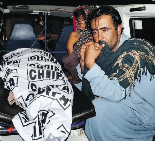  ?? ARSHAD BUTT / THE ASSOCIATED PRESS ?? Mourning relatives take a bombing victim for burial in Quetta, Pakistan, on Friday after a suicide bomber attacked a political rally in the nearby town of Mastung. Siraj Raisani, one of the candidates, was also killed in the blast.