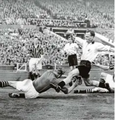  ?? Foto: dpa Archiv ?? Der deutsche Torhüter von Manchester City, Bert Trautmann, fängt den Ball vor ei nem heranstürm­enden Stürmer.