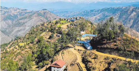  ?? FOTO: MICHAEL HÖSCHELE ?? Ein Blick auf das Dorf Lurpung in Nepal: Im Vordegrund ist ein Lehrerwohn­haus zu sehen, das der Verein „Himalayan Project“errichtet hat, dahinter die Schule (blaue Dächer). Am Horizont sind die Gipfel des Himalaya-Gebirges mit zum Teil mehr als 8000 Metern Höhe zu erkennen.