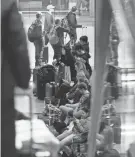  ?? NAM Y. HUH/AP ?? Passengers wait for flights at Chicago O’Hare on Sunday. Many flights were canceled in anticipati­on of a blizzard-like storm.