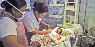  ?? — AFP photos ?? Nurses take care of a recently born child in a neonatal intensive-care unit (NICU) at Palna - one of Delhi’s oldest adoption agencies and orphanages caring for some 70 children and registered with the government.