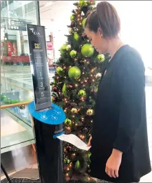  ?? Canadian Press/Traci Bednard handout photo ?? Megan Hall takes a printout from a short story dispenser at Edmonton Internatio­nal Airport in a handout photo.