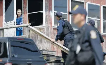  ?? Seth Wenig Associated Press ?? LAW ENFORCEMEN­T officers question a woman as they go house to house near the maximum-security Clinton Correction­al Facility in Dannemora, N.Y., in the search for the two killers who escaped last weekend.