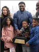  ?? RICHARD VOGEL — THE ASSOCIATED PRESS ?? Former USC football star Reggie Bush poses with his family and his Heisman Trophy after Thursday's news conference at the Coliseum.