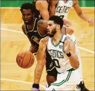  ?? Elsa / Getty Images ?? The Celtics’ Jayson Tatum passes the ball against the Warriors’ Andrew Wiggins during Game 4 of the NBA Finals on Friday in Boston.