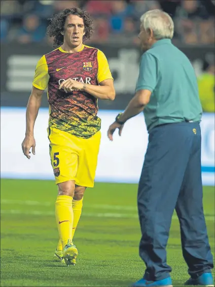  ?? FOTO: CHAVES ?? Puyol, antes del Osasuna-Barça de la Liga 2013-14, con una camiseta de entrenamie­nto donde aparece el Eixample. Hubo dos modelos