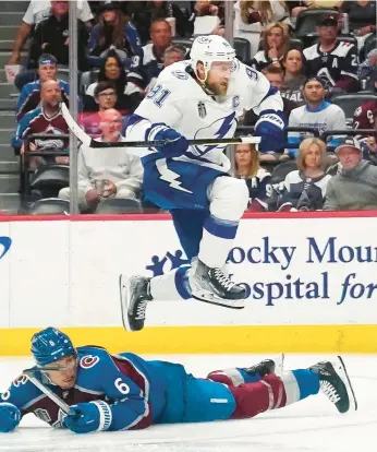  ?? JOHN LOCHER/AP ?? Steven Stamkos jumps over the Avalanche’s Erik Johnson during Game 1 of the Stanley Cup Final on Wednesday.