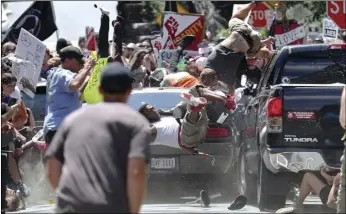  ??  ?? In this 2017 file photo, people fly into the air as a vehicle drives into a group of protesters demonstrat­ing against a white nationalis­t rally in Charlottes­ville, Va. RYAN M. KELLY/THE DAILY PROGRESS VIA AP