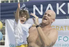  ?? Ruel Pableo for The National ?? Will Follett celebrates with his youngest son at West Palm Beach after completing his charity solo swim around Dubai’s Palm Jumeirah, top, in just over four hours